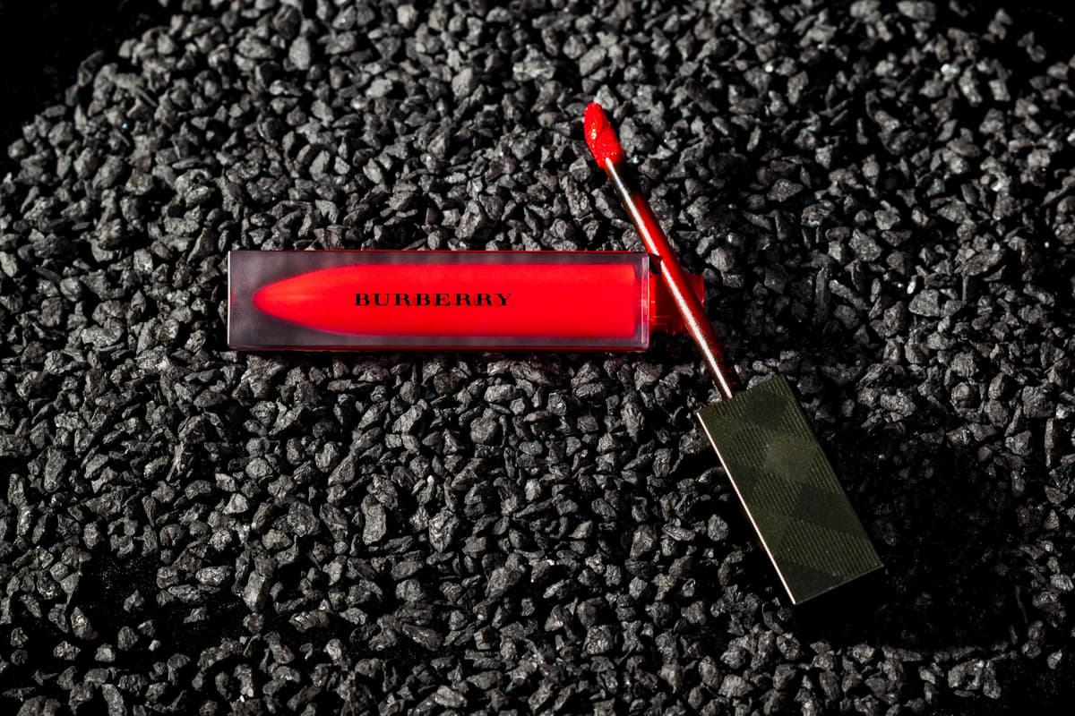 Burberry red lip gloss on black gravel